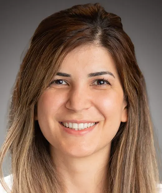 A woman with long hair smiles for the camera.