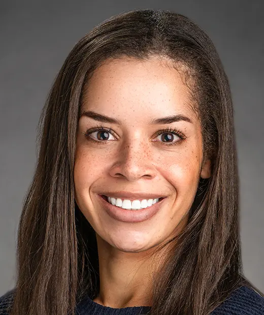 A woman with long hair smiles for the camera.