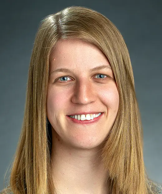 A woman with long hair smiles for the camera.