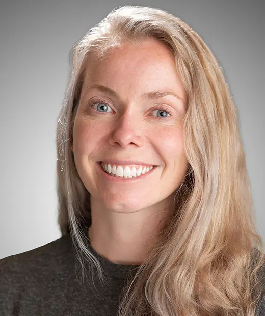 A woman with long blonde hair smiles for the camera.