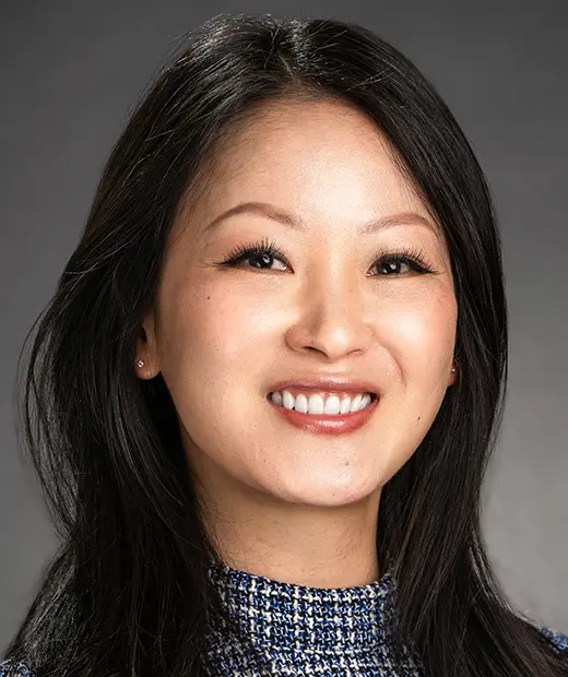 A woman with long black hair smiles for the camera.