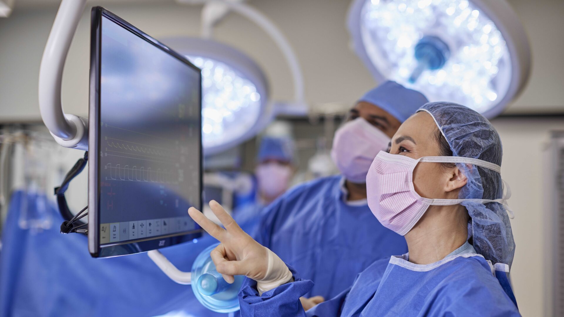 A group of doctors in blue scrubs and masks.