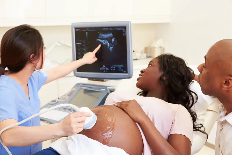 A pregnant woman is playing with the ultrasound of her baby.