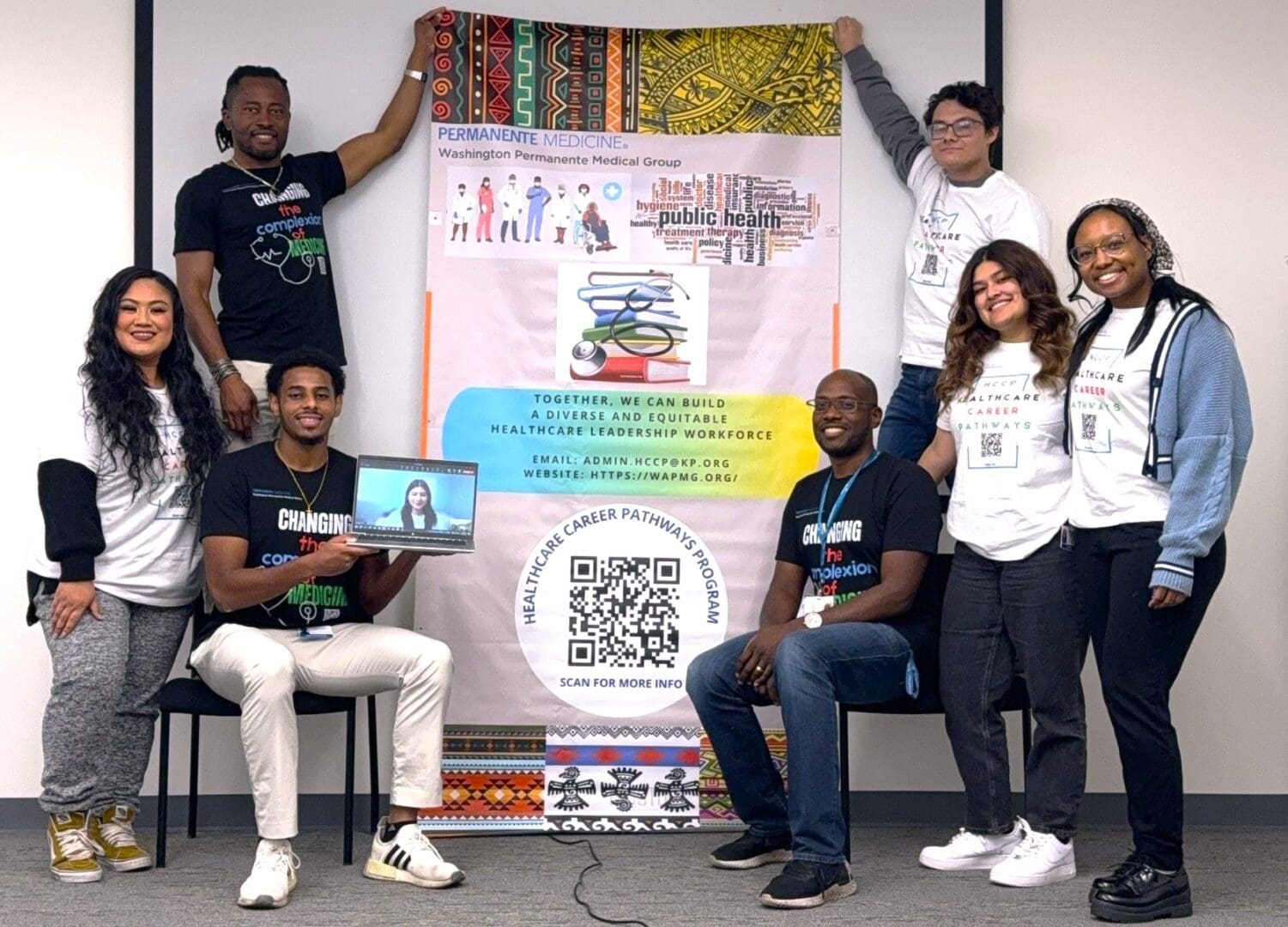 A group of people posing for a picture in front of a banner.