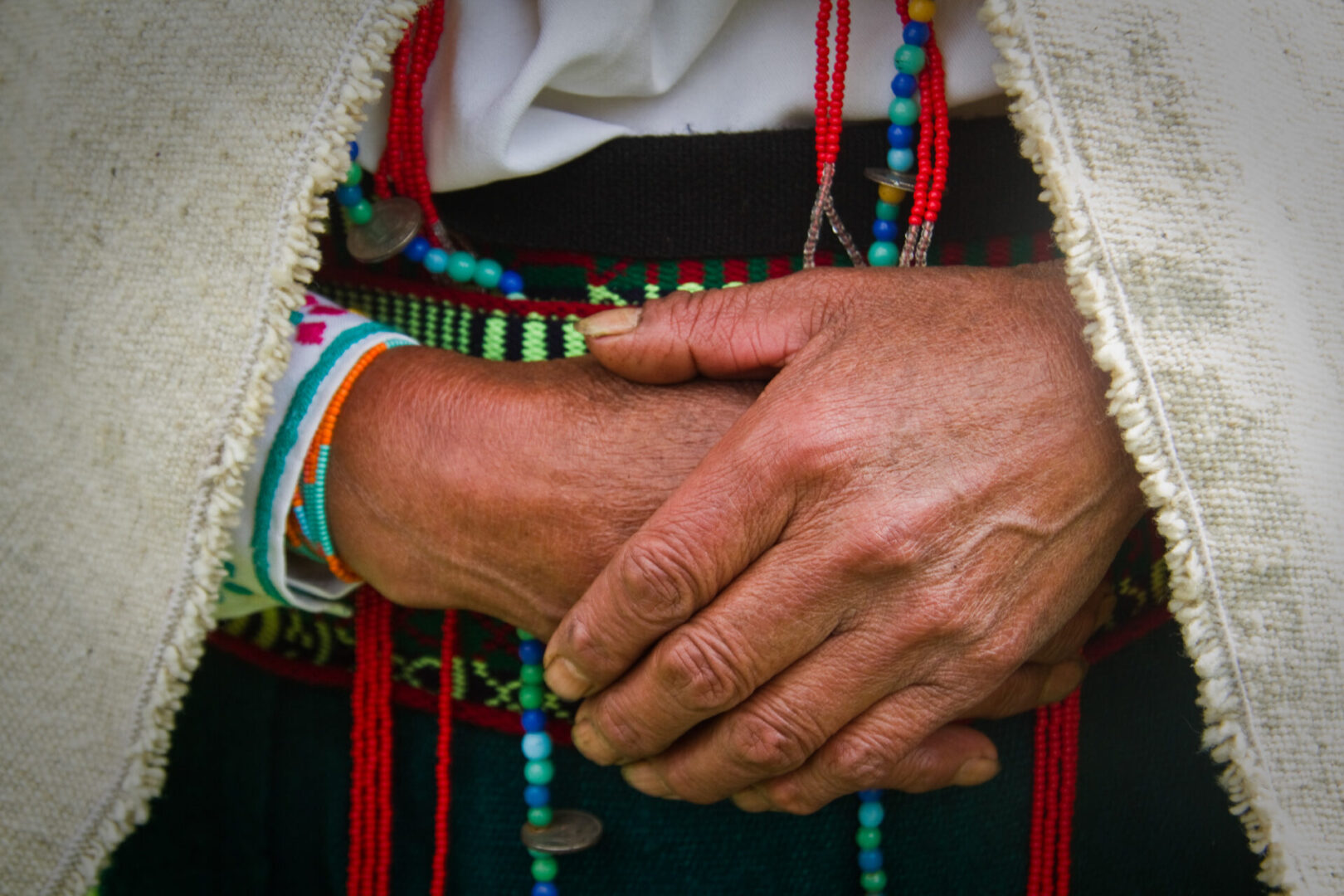 A person wearing bracelets and holding their hands