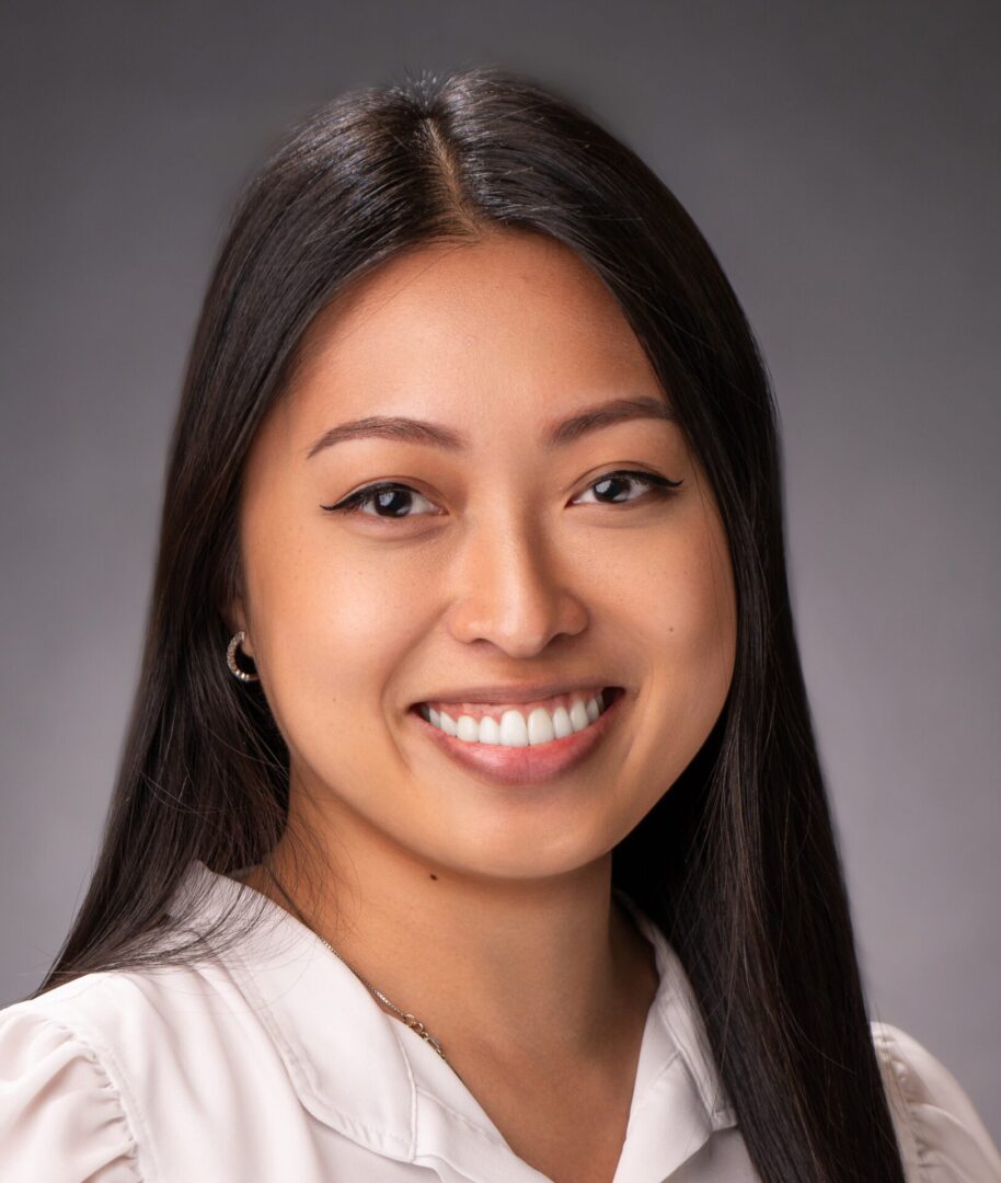 A woman with long hair smiles for the camera.