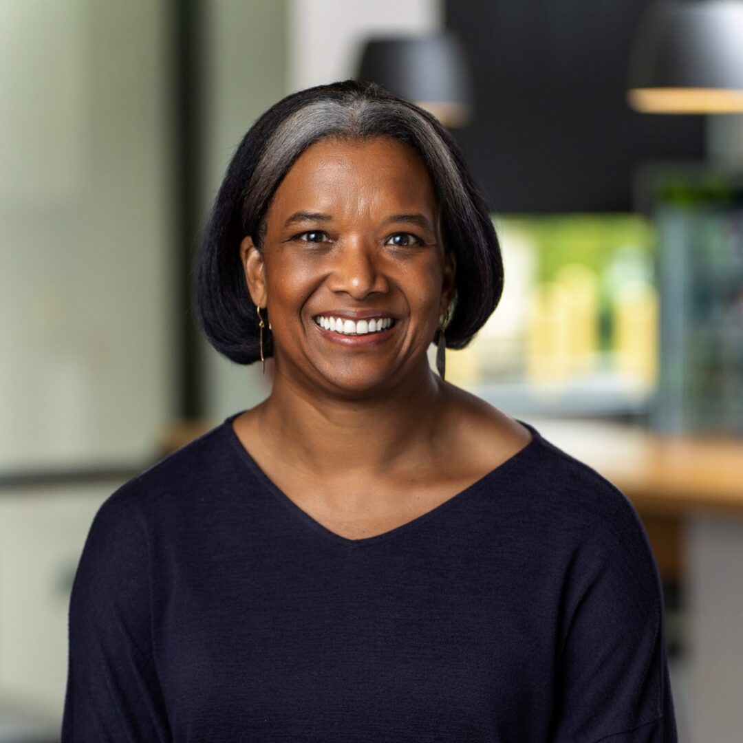 A woman with short hair is smiling for the camera.